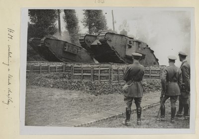 3人の将校、1人はおそらくジョージV王で、2つの戦車が障害物を越えて運転されているのを見ていた、1915年から18年 作： English Photographer